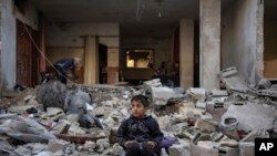 Një fëmijë palestinez ulet në rrënojat e një ndërtese të shkatërruar nga sulmi izraelit në Rafah, në jug të Gazës, 29 dhjetor 2023.