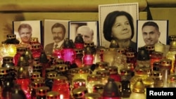 Poland -- Pictures of the victims of Polish government Tupolev Tu-154 aircraft crash are placed with candles in front of St. Anna's Church near the Presidential Palace in Warsaw, 12Apr2010