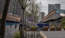 ჩინელი პოლიციელის რეაქცია ფოტოგრაფზე, რომელიც „ჰუანანის“ დახურულ ბაზარს იღებს უჰანში. 2020 წ. 30 მარტი.