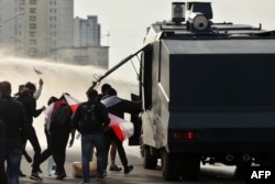 Протестующие разбирают водомет 4 октября во время акции за освобождение политзаключенных в Минске