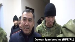 Равшан Джеенбеков в сопровождении сотрудников силовых структур.