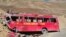 FILE: People stand beside the wreckage of a passenger bus at the scene of its accident near Chilas in Gilgit-Baltistan in September 2019.