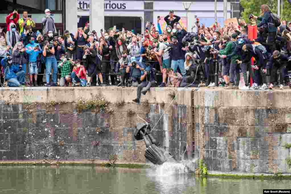 Statuia lui Edward Colston cade în apă, după ce protestatarii au tras-o de pe soclu și a fost împinsă în docuri, în timpul unui protest față de inegalitățile rasiale.