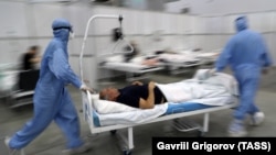 Stafi mjekësor duke bartur një pacient të infektuar me koronavirus, jashtë Moskës.