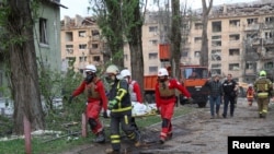 Орус армиясынын соккусунан набыт болгон тургундун сөөгүн парамедиктер көтөрүп баратышат. 24-апрель, 2025-жыл. Киев.