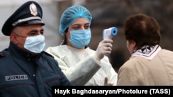 Медична працівниця перевіряє температуру у жінки на в’їзді до міста Вагаршапат, 16 березня 2020 року