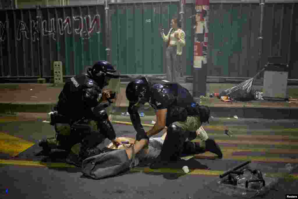 Сотрудники правоохранительных органов задерживают демонстранта во время антиправительственной акции с требованием проведения досрочных выборов, Белград, Сербия, 28 июня 2025 года. REUTERS/Marko Djurica