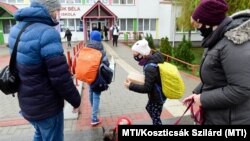 Diákok érkeznek a Gyáli Bartók Béla Általános Iskolába 2021. április 19-én. Az általános iskolák alsó tagozatai ezen a napon visszatérnek a tantermi oktatáshoz, és kinyitottak az óvodák is