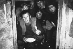 Un bărbat ține în mână, după cum susține el, ultimul știulete de porumb, în timpul asediului de la Srebrenica.