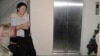 Выселенная из квартиры Умит Нуртазина сидит у лифта. Астана, 28 марта 2013 года. 