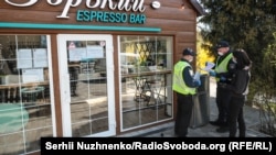 Працівники поліції складають протокол про порушення роботи кав'ярні під час карантину,в ботанічному саду імені Олександра Фоміна. Київ 4 квітня 2020 р.