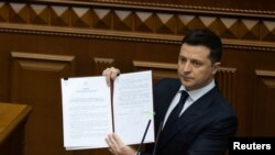 Ukrajinski predsjednik Volodymyr Zelenskiy pokzuje dekret dok drži govor na sjednici parlamenta u Kijevu, Ukrajina, 1. februara 2022.