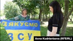 Ангеліна Шостак із прапором з підписом Валерія Залужного та кореспондентка Радіо Свобода Ірина Сисак