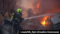 Рятувальник гасить пожежу, що виникла внаслідок російської атаки, Київ, 6 квітня 2025 року