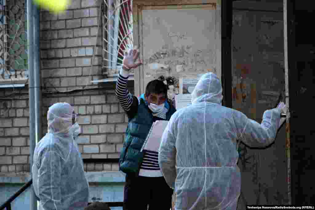 Медпрацівники розмовляють з одним із мешканців гуртожитку в Запоріжжі, в якому виявили COVID-19