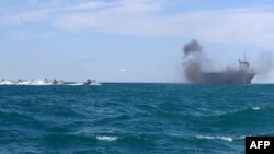 قایق‌های تندروی سپاه در حال نزدیکی به یک کشتی در جریان یک رزمایش آبی در تنگه هرمز