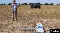 Фермер оглядає російський бойовий безпілотник, який впав на його поле під час нападу Росії на Україну, Херсонська область, Україна, 24 липня 2025 року