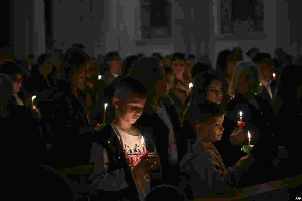 Христијански верници држат свеќи на Велигденското бдение во катедралата Света Мајка Тереза ​​во Приштина, Косово на 19 април 2025 година.
