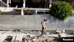 Žena prolazi pored ruševina zgrade oštećene u borbama u gradu Šir, region Tigraj. mart 2021. 