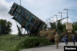 Українські військовослужбовці йдуть поруч із пусковою установкою системи протиповітряної оборони Patriot в нерозголошеному місці, Україна, 4 серпня 2024 року