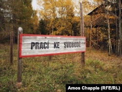 یک تابلوی بازسازی‌شده در مقابل یکی از اردوگاه‌های کار اجباری در یاخیموف، که می‌گوید «کار شما را آزاد می‌کند».