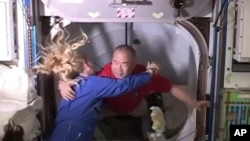 АҚШ астронавты Кейт Рубинс халықаралық ғарыш станциясына Жерден ұшып барған жапон астронавты Соити Ногутиді (оң жақта) қарсы алып жатыр. 17 қараша 2020 жыл. NASA видеосынан скриншот.