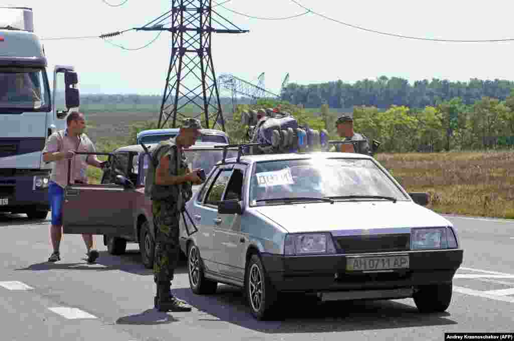 Un militar ucrainean verifică documente la un punct de control de lângă Mariinka, în august 2014. &nbsp;