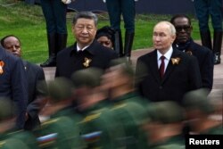 Президент Росії Володимир Путін та президент Китаю Сі Цзіньпін спостерігають за маршем російських військовослужбовців з нагоди 80-ї річниці перемоги над нацистською Німеччиною у Другій світовій війні в Москві, Росія, 9 травня 2025 року