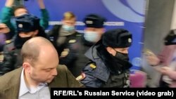 Москвоская полиция среди муниципальных депутатов, собравшихся на свой форум. На первом плане - оппозиционный политик Владимир Кара-Мурза