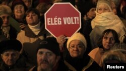 Жінка тримає знак із надписом «Досить!» під час акції протесту в центрі Будапешта, 2 січня 2011 року