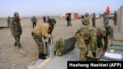 NATO troops along with Afghan National Army (ANA) soldiers prepare shells during a training session of ANA soldiers at Arena base in the Guzara district of Herat Province.