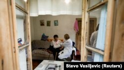 Egy egészségügyi dolgozó beadja a koronavírus elleni vakcinát egy idős nőnek a távoli hegyvidéki faluban, Dragovica Poljeban, Montenegróban, 2021. május 10-én 