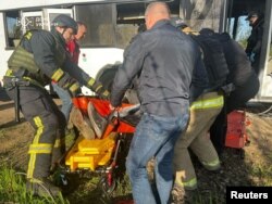 Спасатели эвакуируют раненого человека из автобуса, Марганец, Украина, 23 апреля 2025 года