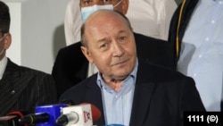 Fostul președinte Traian Băsescu, lider al Mișcării Populare, la o conferință de presă înainte de alegerile locale din septembrie 2020. Traian Băsescu și-a asigurat al doilea mandat printr-o serie de manevre politice care au eliminat PSD din alianța cu PDL, condus pe atunci de Emil Boc. Numirea succesivă de premieri era menită nu să ducă la anticipate, ci să asigure continuitatea la putere.