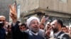 Hassan Rohani flashes the sign of victory as he leaves a polling station after voting in Tehran on June 14.