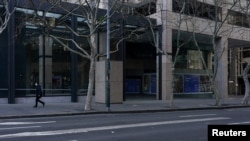 Pješak koji nosi masku za lice prolazi kroz mirni centar grada tokom zatvaranja, Sidnej, Australija, 18. augusta 2021. 