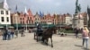 A belvárosokban legegyszerűbb lovaskocsin közlekedni. Ez Bruges főtere.
