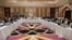 FILE: Qatari officials (C) take part in meeting between U.S. special envoy Zalmay Khalilzad (2nd-L), and the U.S. delegation, and Sher Mohammad Abbas Stanikzai (6th-R), and the Taliban delegation, in the Qatari capital Doha in February.