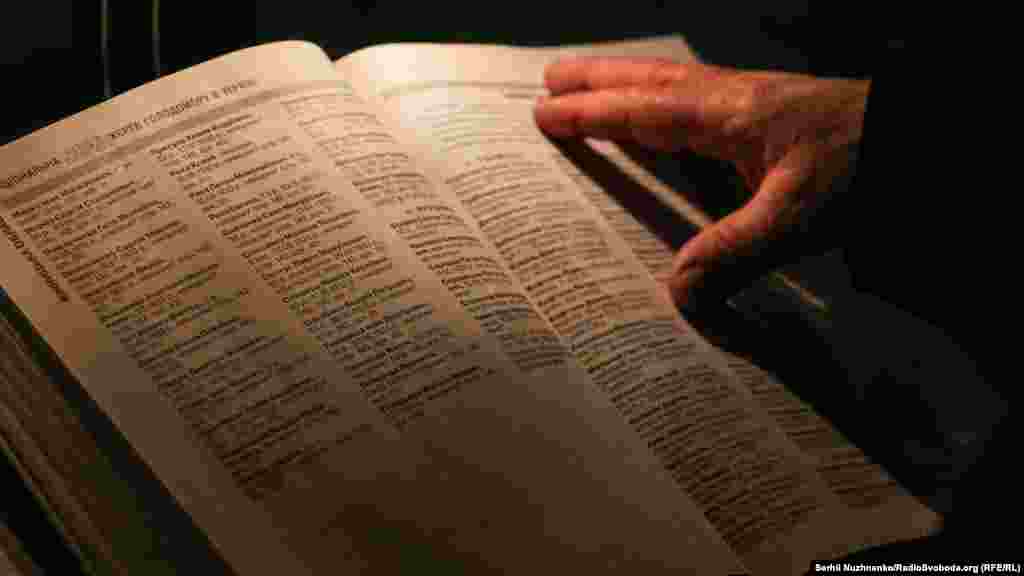 Люди в книзі пам&#39;яті шукають імена померлих родичів.