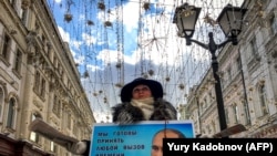 Активіст роздає летючки на підтримку кандидата у президенти Володимира Путіна в центрі Москви 16 березня 2018 року