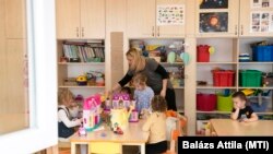 Óvodásokat almával kínál az óvónő Nyíregyházán, 2021. március 10-én