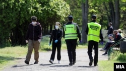 Архивска фотографија- Луѓе со заштитни маски и полиција во Градски парк во Скопје