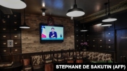 Emmanuel Macron francia elnök televíziós beszéde látható a kijárási korlátozásokról egy párizsi bárban 2020. október 28-án.