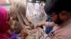 A health worker in Peshawar administers the polio vaccine to children during a three-day countrywide vaccination campaign on August 26.