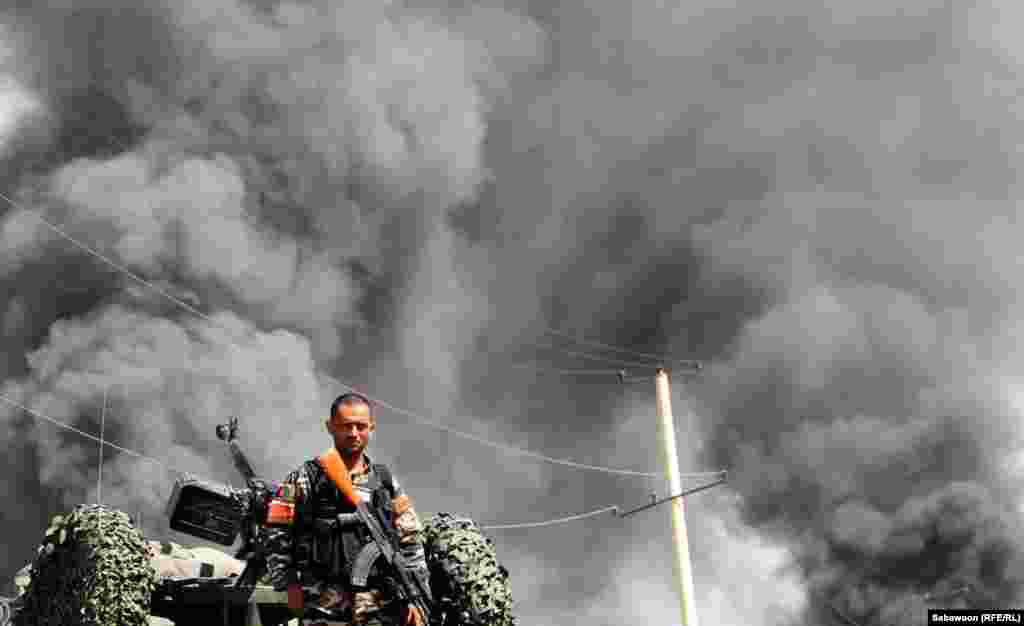 Афганский военнослужащий на месте теракта в пригороде Кабула 2 мая. Теракт произошел через несколько часов после того, как президент США Барак Обама покинул афганскую столицу, подписав соглашение о 10-летнем стратегическом партнерстве между США и Афганистаном. Движение талибов осудило договор. (RFE/Сабавун)