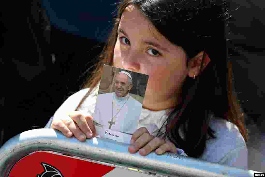 Девочка держит фотографию покойного папы римского Франциска в день его похорон. Рим, Италия, 26 апреля 2025 года. REUTERS/Mohammed Salem