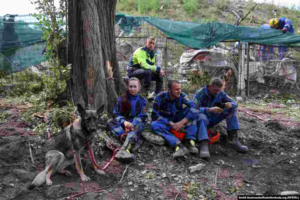 Виснажені рятувальники після розбору завалів на місці влучання російської ракети у Святошинському районі. Київ, 1 серпня 2025 року 