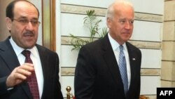Iraqi Prime Minister Nuri al-Maliki (left) walks with U.S. Vice President Joe Biden in Baghdad on January 13.