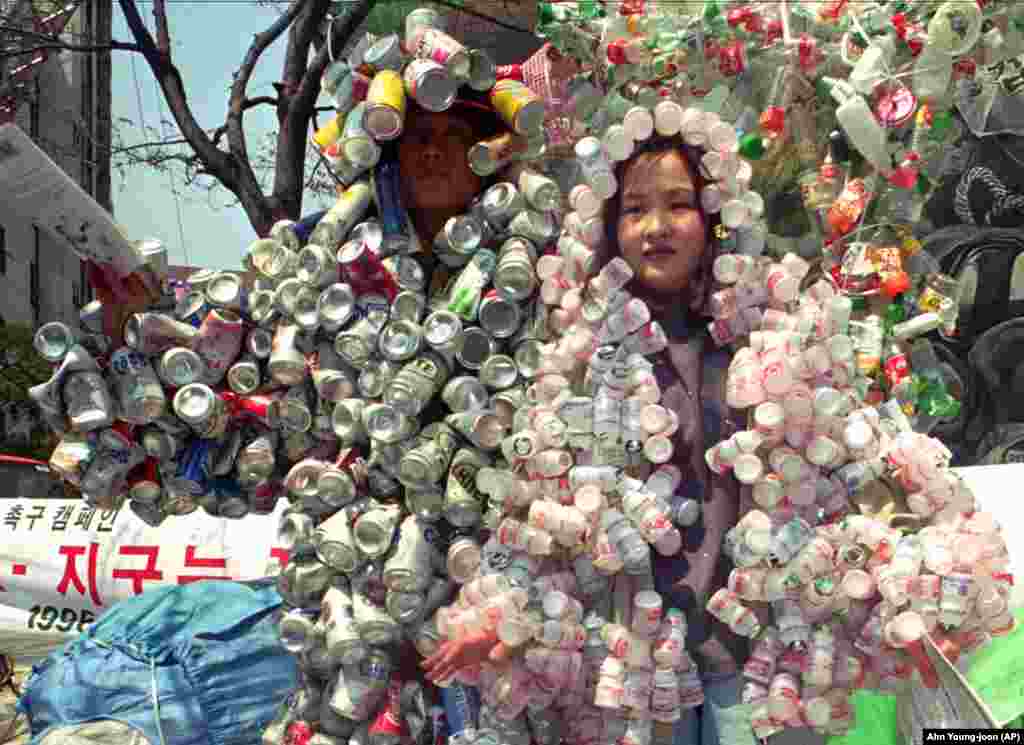 Члени екологічної групи одягли жмут використаних банок на мітингу під час відзначення 26-го Дня Землі в центрі Сеула, Південна Корея, 22 квітня 1996 року