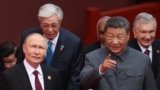 TOPSHOT - In this pool photograph distributed by the Russian state agency Sputnik, Russia's President Vladimir Putin (L) speaks with China's President Xi Jinping after a group photograph before a military parade marking the 80th anniversary of victory ove